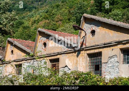 Old obsolete industrial building facade with broken windows Stock Photo