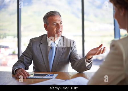 Taking his team to the top. a mature businessman discussing work with a colleague in the boardroom. Stock Photo