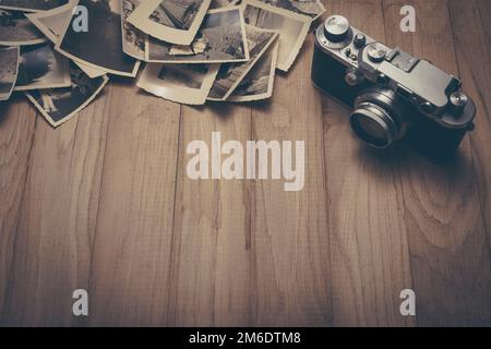 Vintage photo camera with old photos. Stock Photo