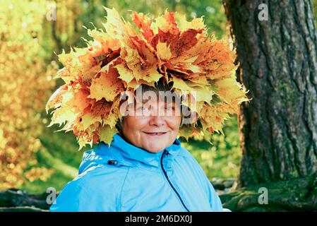 A woman with a wreath of yellow maple leaves on her head. Stock Photo