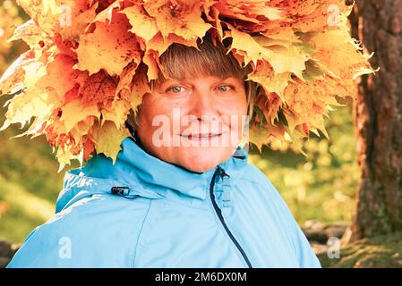 A woman with a wreath of yellow maple leaves on her head. Stock Photo