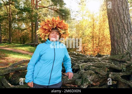 A woman with a wreath of yellow maple leaves on her head. Stock Photo