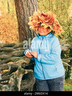 A woman with a wreath of yellow maple leaves on her head. Stock Photo