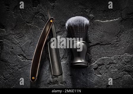 Black Barber Tools. Shaving Brush And Opened Straight Razor With Classic Wooden Handle On Abstract Dark Background Stock Photo