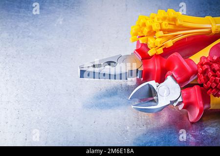 Composition of nippers pliers tying cables on scratched metallic background. Stock Photo