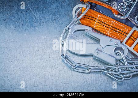 Construction safety strap metal chain carabiner on metallic background. Stock Photo