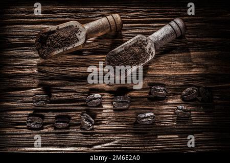 Ground coffee beans in scoop on vintage wooden board. Stock Photo