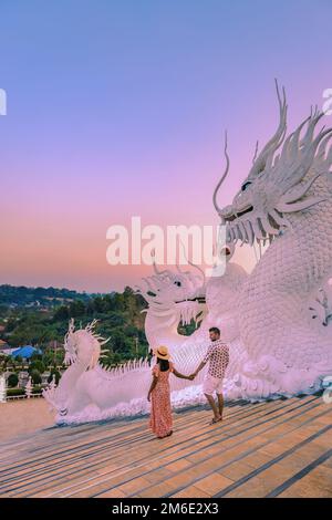 Couple visit Wat Huay Pla Kung temple in Chiang Rai Thailand during sunset, Big Buddha Temple during sunset in Chiang rai Stock Photo