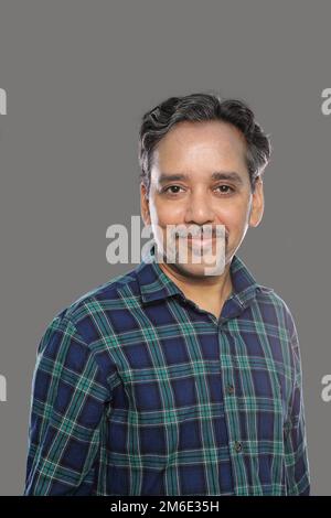Smiling Indian Man in Casual shirt in 40s on grey background Stock Photo