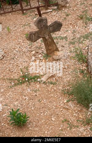 old historical cross of Jesus stuck askew in the ground Stock Photo