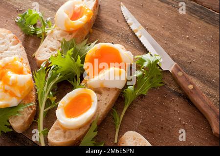 Tasty soft boiled eggs and salad greens Stock Photo