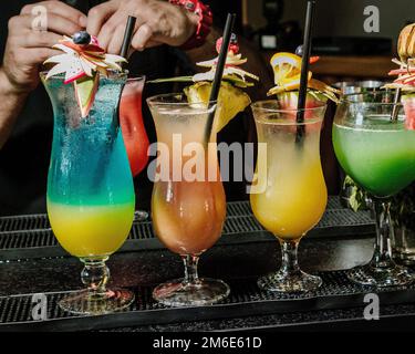 Cocktails drinks on the bar. Alcoholic cocktail row on bar table, colorful party drinks. Stock Photo