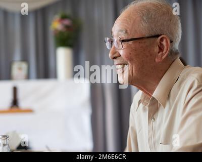 An old man talking animatedly at a family event Stock Photo