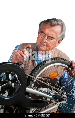 Senior man repairs bike isolated on white Stock Photo