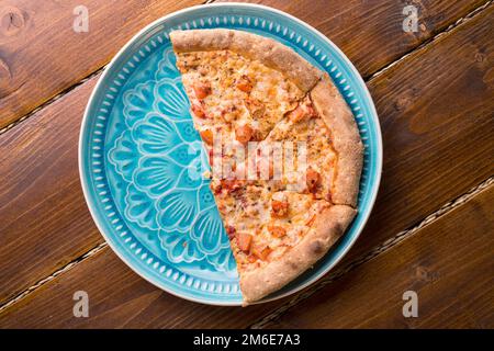 Pizza margarita with tomato and  mozzarella cheese. served at beautiful blue dish on wooden table. flat lay Stock Photo