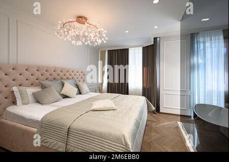 Big comfortable double bed in elegant classic bedroom Stock Photo