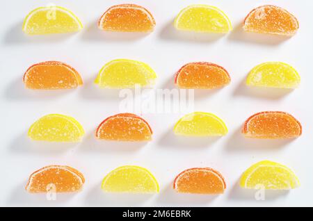 Background of marmalade in the form of citrus fruits slices, top view. Jelly candies in sugar sprinkles Stock Photo