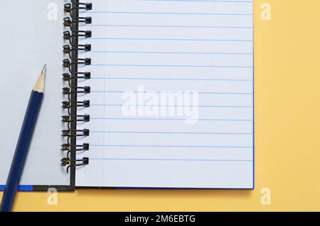 Opened notebook and pencil on old wooden background close up, top view Stock Photo