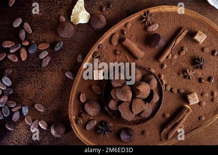 Healthy delicious chocolate truffles around ingridients with natural cacao beans,  powder, cacao butter, cane sugar. healthy swe Stock Photo