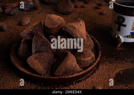 Healthy delicious chocolate truffles around ingridients with natural cocoa beans,  powder, cacao butter, cane sugar and cup of c Stock Photo