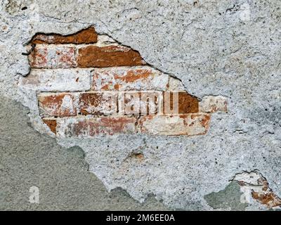 Close-up of facade with peeling plaster on brick as background Stock Photo