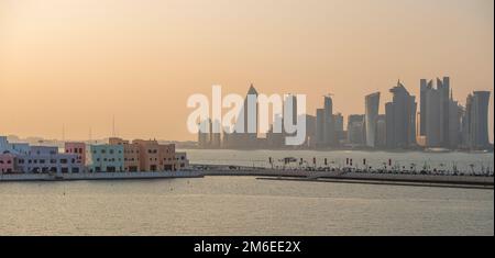 Mina District Corniche (left) and buildings on the waterfront in Doha, Qatar, including the Tornado Tower, also called the QIPCO Tower, the Burj Doha Stock Photo