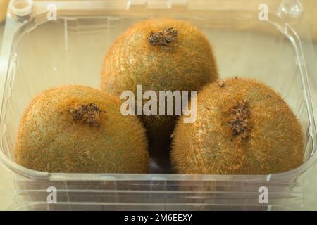 Freshly bought Kiwi fruits in plastic packaging box. Day light. Stock Photo