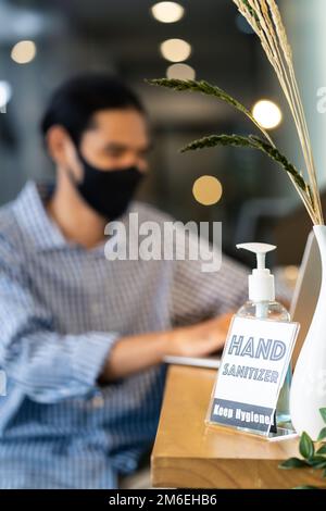 Hand Sanitizer in office with businessman wear face mask Stock Photo