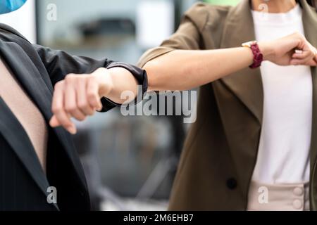 Businesswomen wear face mask elbow greeting in new normal office lifestyle Stock Photo