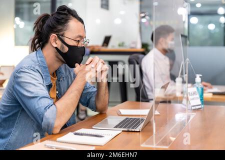 Asian businessman working in new normal and social distance office Stock Photo