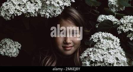 Cute little girl smelling lilac Stock Photo