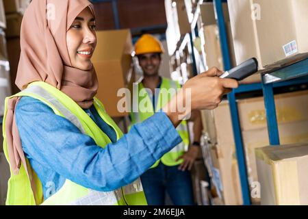 Asian Islam Muslim warehouse worker do inventory Stock Photo