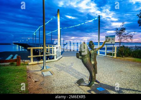 The Boy and the Fish sculpture at the entrance to historic Urangan pier,at dawn, Hervey Bay, Queensland, Australia Stock Photo