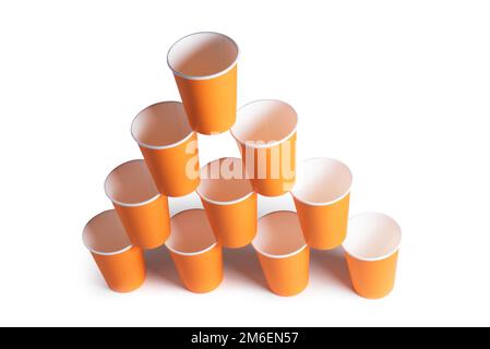 Pyramid of orange disposable paper cups isolated on white background. Stock Photo