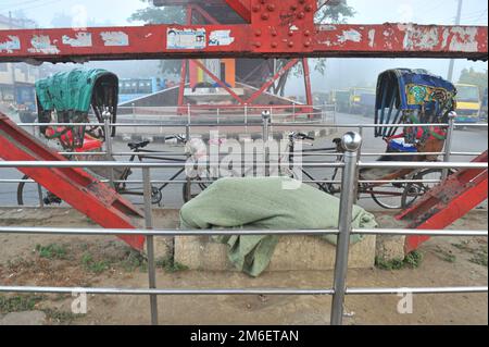 Non Exclusive: 04 January 2023 In Sylhet-Bangladesh: A Rickshaw Pullar is sleeping on street in deep foggy winter morning in Sylhet, Bangladesh. Cold Stock Photo