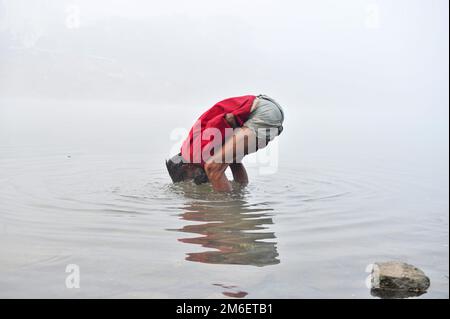 Non Exclusive: 04 January 2023 In Sylhet-Bangladesh: A man is seen wash his face and hand in the Surma River in deep foggy winter morning in Sylhet, B Stock Photo