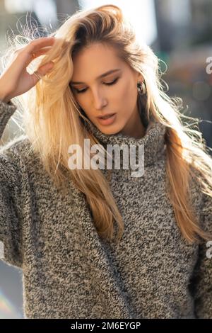 portrait of pretty young woman adjusting blonde hair in New York city,stock image Stock Photo