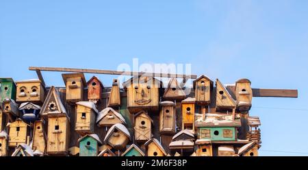 Many different forms of bird feeders.Birdhouses hang on a wooden fence Stock Photo