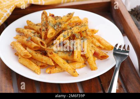 Food - Tasty Penne Pasta Plate with a Fork on Wooden Tray Stock Photo