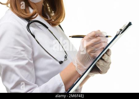 Hands of a doctor in gloves writes with a ballpoint pen in a tablet, close-up Stock Photo
