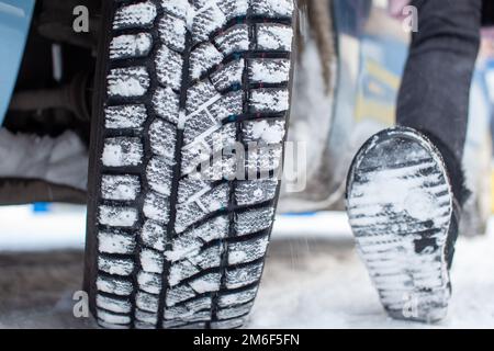 Car tires on the winter road are covered with snow. Stock Photo