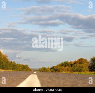 A long white stripe, like a road marker. A road between fields Stock Photo