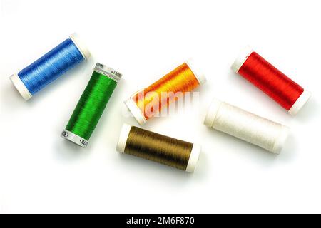 Multicolored sewing threads isolated on white background. Color thread spools on white background, top view. Stock Photo