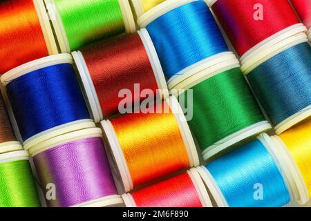 Multicolored sewing threads. Background of spools with color sewing threads, top view. Stock Photo