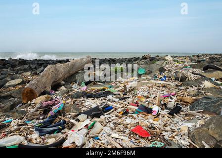 Spilled garbage on the beach near the big city. Empty used dirty plastic bottles and other garbage. Environmental pollution. Eco Stock Photo
