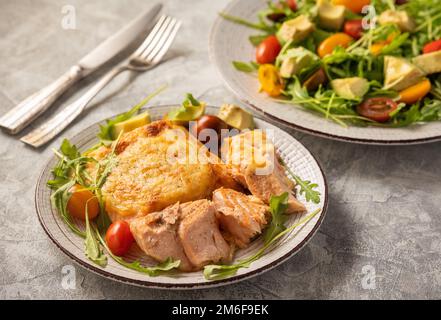 Salmon baked with cheese, served with vegetables. Stock Photo