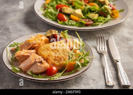 Salmon baked with cheese, served with vegetables. Stock Photo