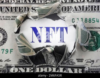 NFT ( Non-Fungible Token ) text in a torn dollar bill Stock Photo