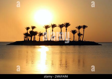 Beautiful place for privacy. Sunset over island in sea. Bright sun during dawn over the sea. Island Stock Photo