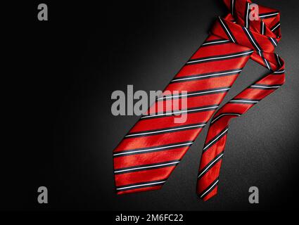 Red men's striped tie isolated on black background Stock Photo
